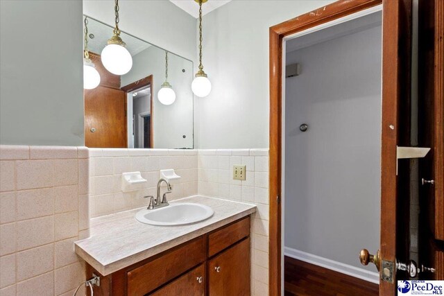 bathroom with vanity, hardwood / wood-style floors, and tile walls