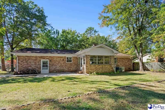 rear view of property featuring a patio area and a lawn