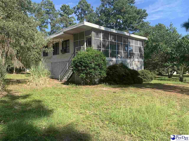 view of side of home featuring a yard and a sunroom