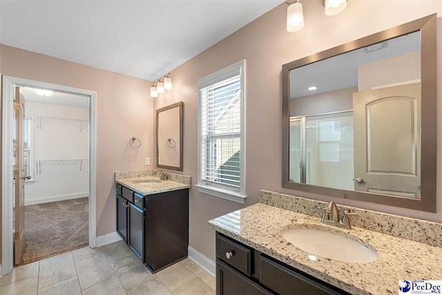 bathroom featuring vanity, a shower with shower door, and tile patterned flooring