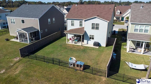back of house with a lawn, a sunroom, and a patio