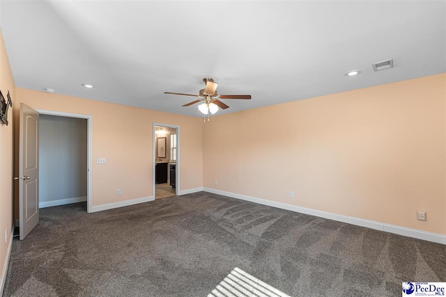 unfurnished bedroom featuring dark colored carpet, connected bathroom, and ceiling fan