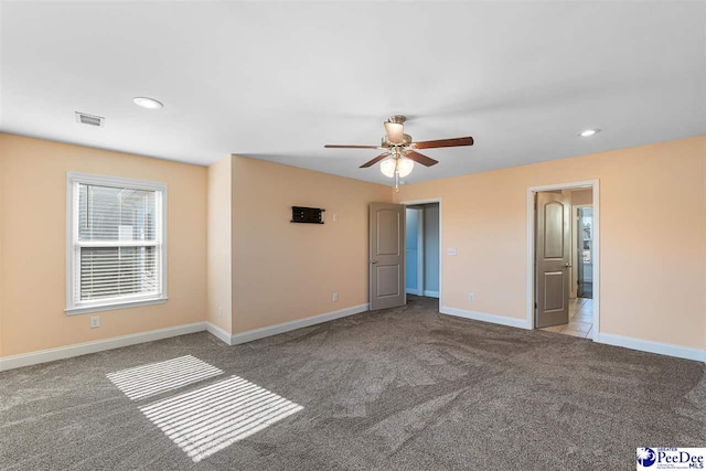 carpeted spare room with ceiling fan