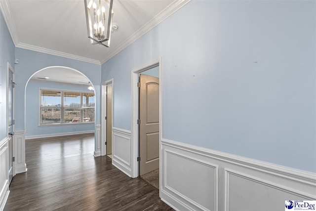 corridor with ornamental molding, dark wood-type flooring, and a notable chandelier