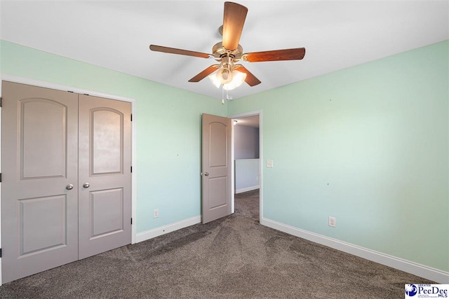 unfurnished bedroom with dark colored carpet, ceiling fan, and a closet