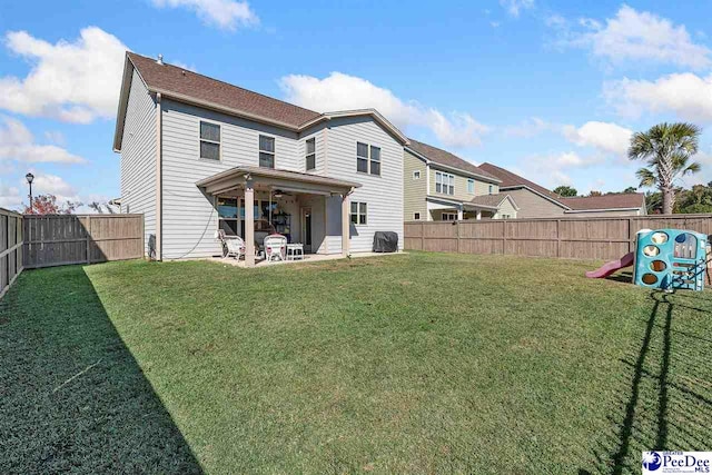 rear view of property featuring a yard and a patio area