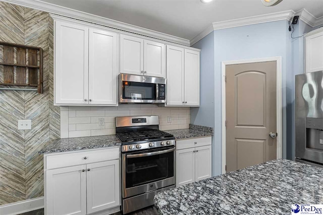 kitchen with white cabinetry, appliances with stainless steel finishes, dark stone countertops, and backsplash