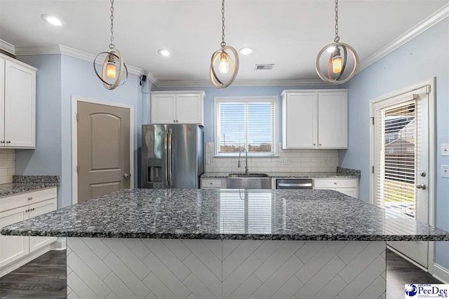 kitchen featuring stainless steel appliances, sink, white cabinets, and dark stone counters