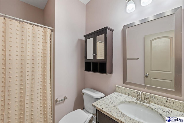 bathroom featuring vanity, toilet, and a shower with shower curtain
