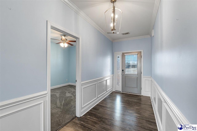 doorway featuring crown molding, dark hardwood / wood-style floors, and ceiling fan with notable chandelier