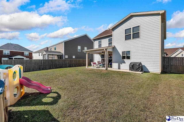 back of property with a playground, a yard, and a patio area