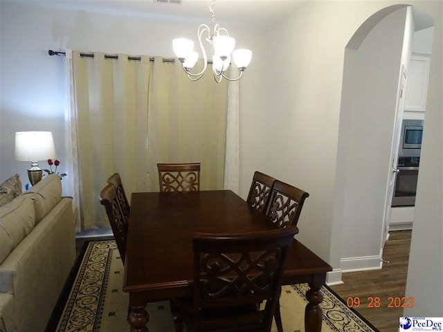 1671 Lake Wateree Dr, Florence, SC 29501 - dining area with a chandelier, arched walkways, wood finished floors, and baseboards