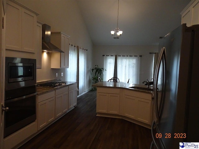 1671 Lake Wateree Dr, Florence, SC 29501 - kitchen with appliances with stainless steel finishes, wall chimney range hood, a sink, dark wood-style floors, and a peninsula