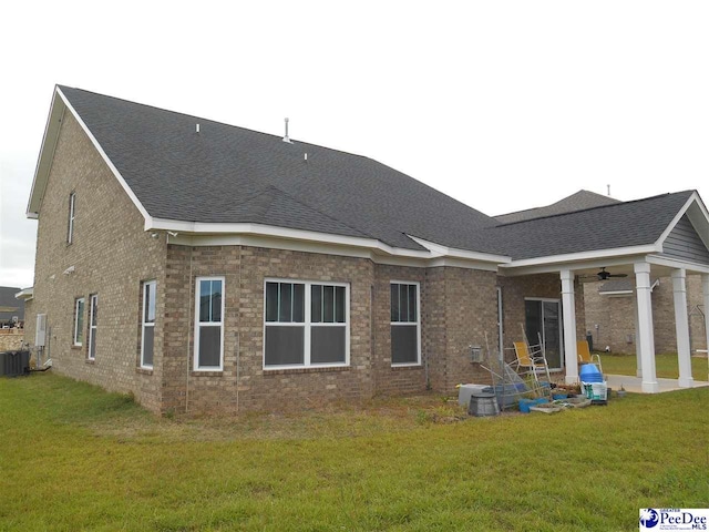 1671 Lake Wateree Dr, Florence, SC 29501 - back of house featuring ceiling fan, a lawn, central air condition unit, and a shingled roof