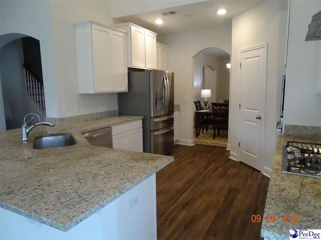 1671 Lake Wateree Dr, Florence, SC 29501 - kitchen with a sink, appliances with stainless steel finishes, a peninsula, dark wood-style floors, and arched walkways