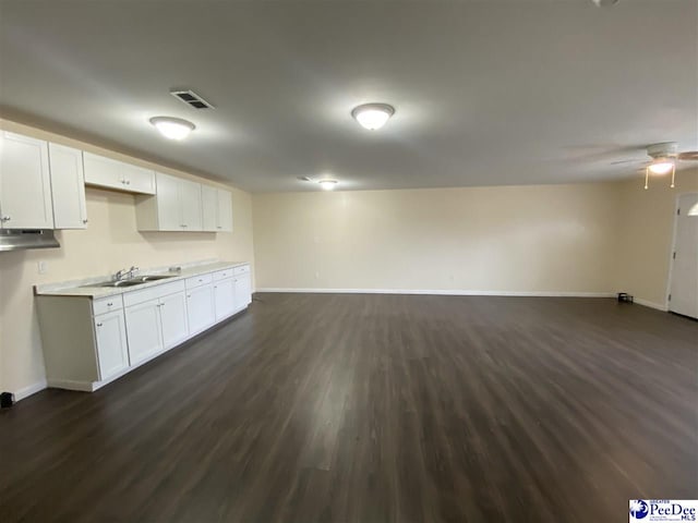 kitchen featuring dark wood-type flooring, ceiling fan, sink, and white cabinets