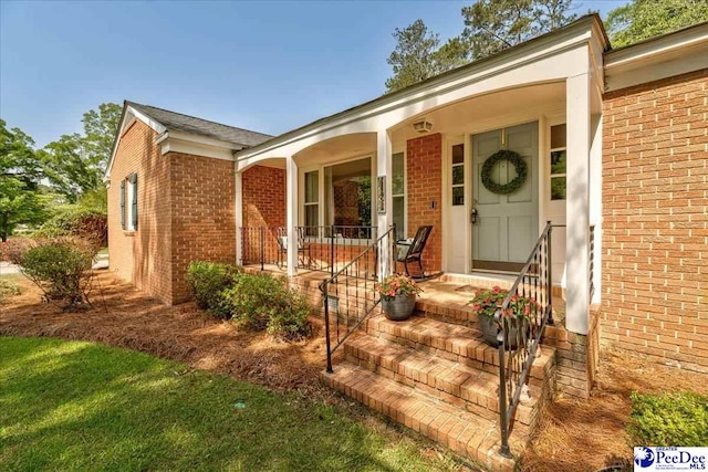 128 Holly Dr, Hartsville, SC 29550 - doorway to property featuring brick siding and covered porch