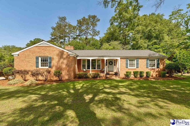 128 Holly Dr, Hartsville, SC 29550 - ranch-style home featuring a front yard, a porch, a chimney, and brick siding