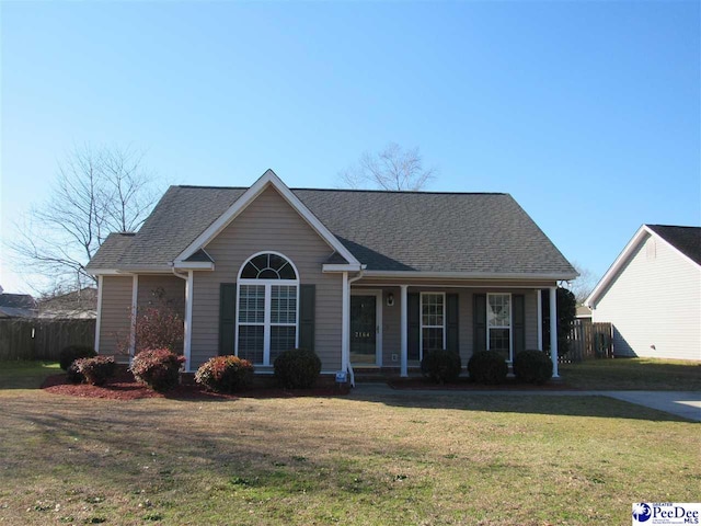 ranch-style home featuring a front lawn and roof with shingles