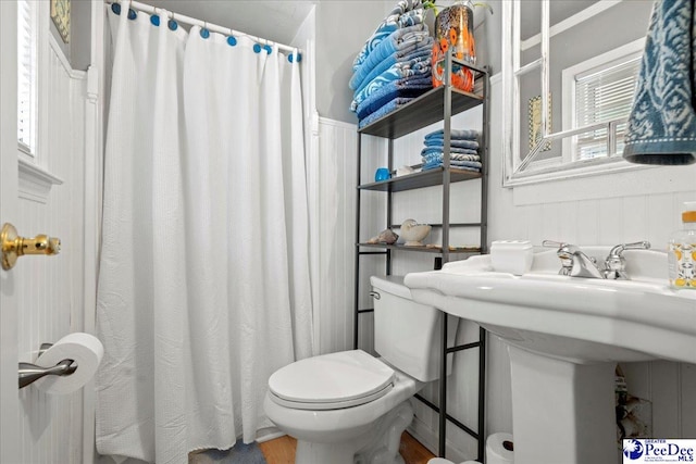 bathroom with a shower with shower curtain and toilet