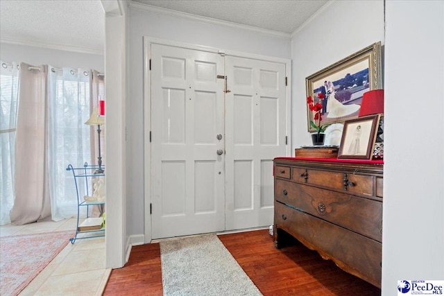 entryway featuring hardwood / wood-style floors, crown molding, and a textured ceiling