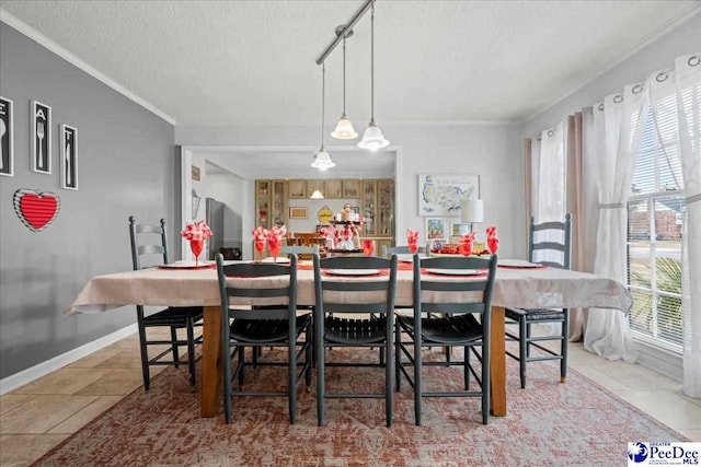 tiled dining area with crown molding and a textured ceiling