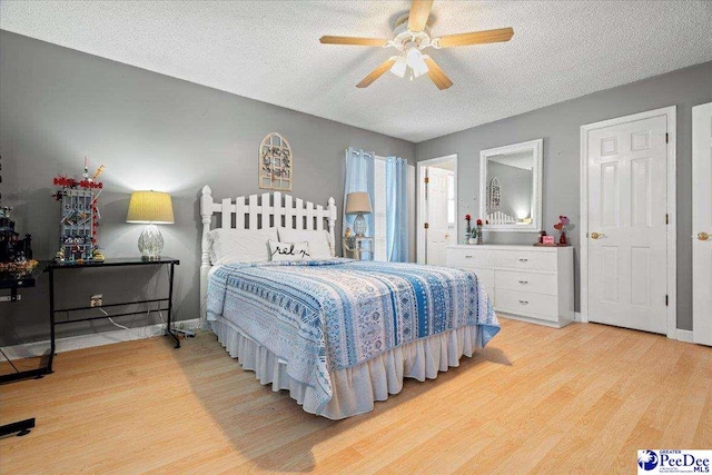 bedroom with ceiling fan, a textured ceiling, and light wood-type flooring