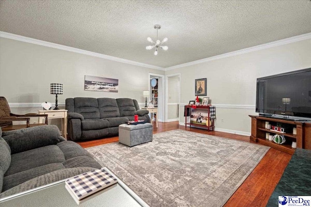 living room with crown molding, hardwood / wood-style floors, and a notable chandelier