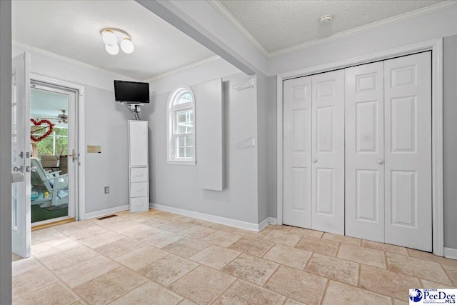 foyer entrance with a wealth of natural light, ornamental molding, and a textured ceiling