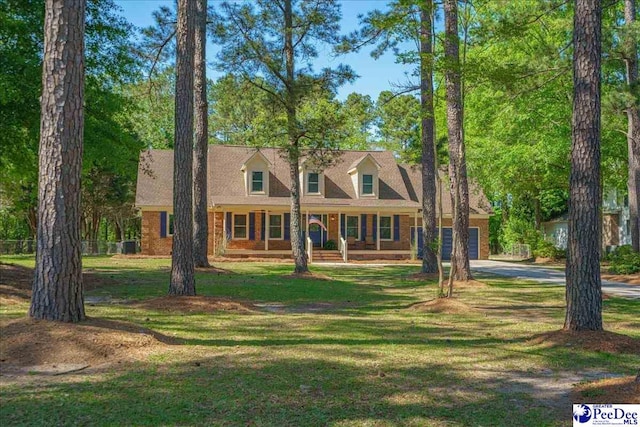 cape cod home with a front yard