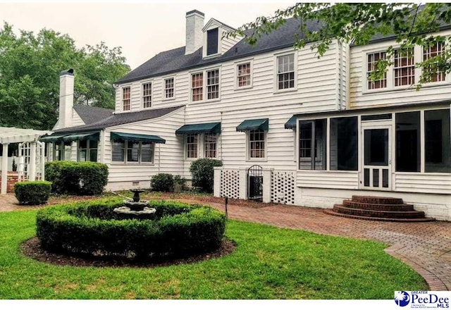 rear view of house featuring crawl space, a lawn, and a chimney