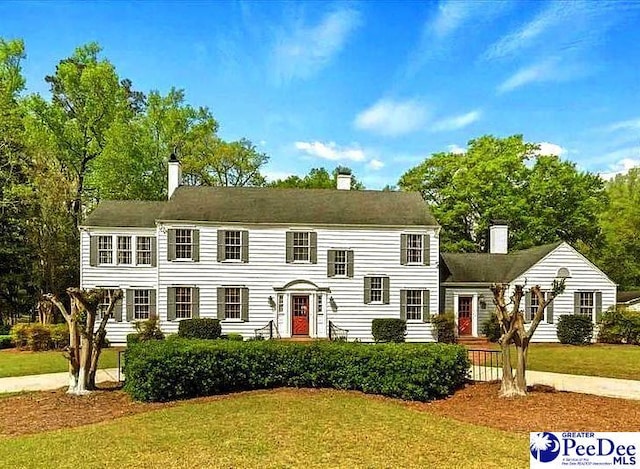 colonial-style house featuring a front yard