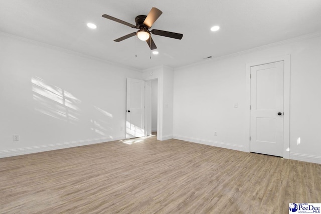 spare room featuring visible vents, crown molding, light wood-style flooring, and baseboards