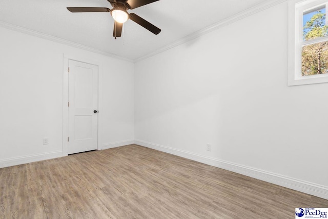 spare room featuring baseboards, ceiling fan, light wood finished floors, and crown molding