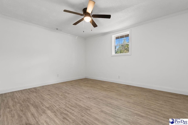 unfurnished room with ornamental molding, a textured ceiling, baseboards, and wood finished floors