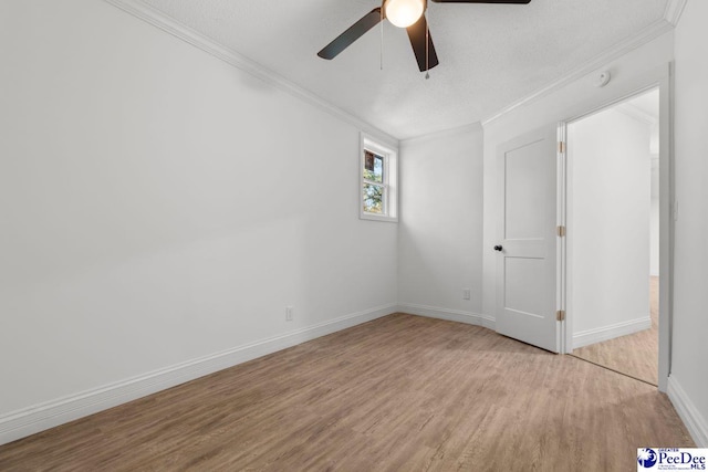 unfurnished bedroom featuring baseboards, ceiling fan, ornamental molding, and light wood-style floors