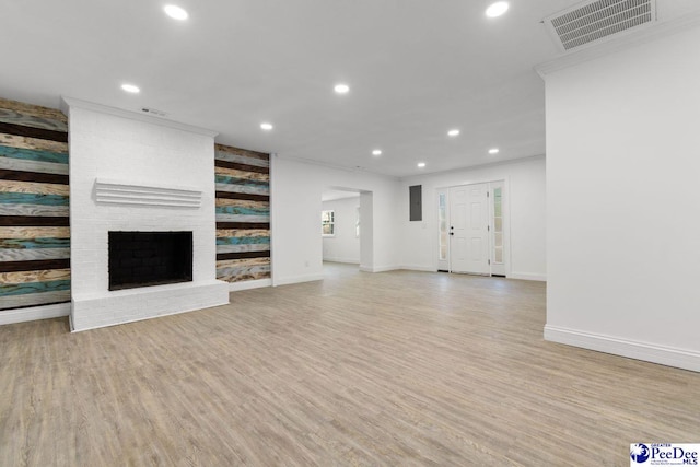 unfurnished living room with a fireplace, recessed lighting, visible vents, light wood-style floors, and baseboards