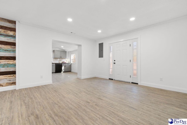 foyer with light wood-style flooring, electric panel, baseboards, and ornamental molding