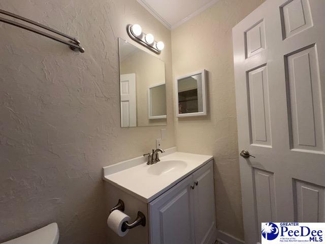 1328 Salem Rd, Hartsville, SC 29550 - half bath with vanity, toilet, crown molding, and a textured wall