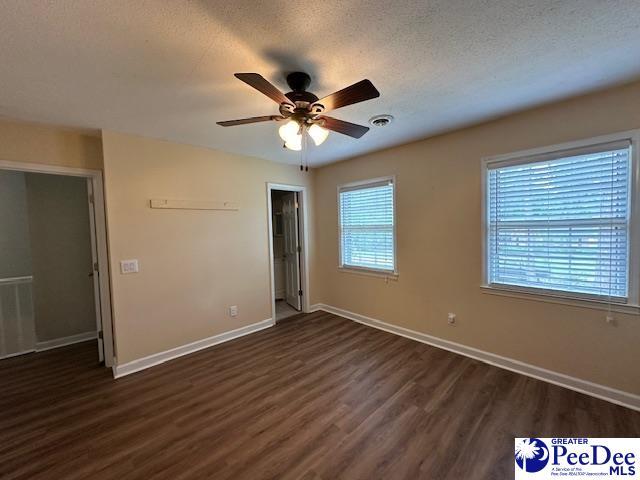 1328 Salem Rd, Hartsville, SC 29550 - unfurnished bedroom with dark wood-style floors, baseboards, and ceiling fan