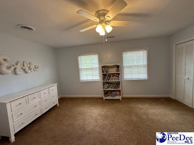 1328 Salem Rd, Hartsville, SC 29550 - bedroom with dark carpet, baseboards, ceiling fan, and a closet