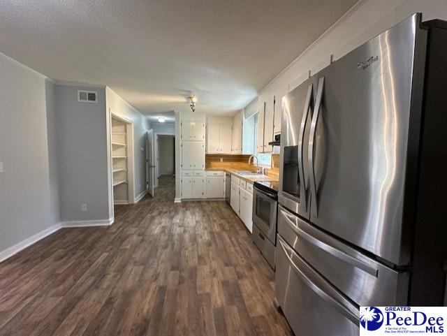 1328 Salem Rd, Hartsville, SC 29550 - kitchen with stainless steel appliances, a sink, white cabinets, light countertops, and dark wood-style floors