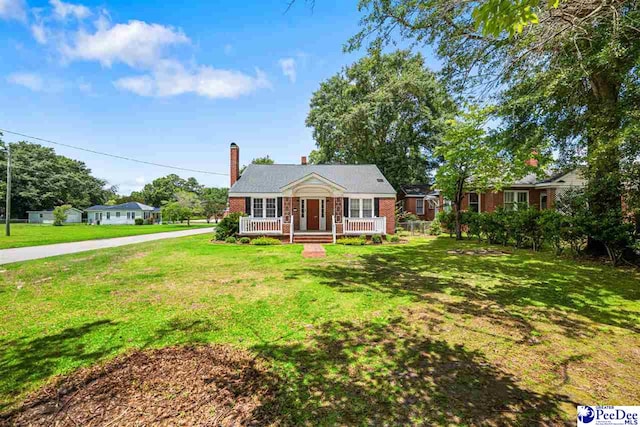 1461 King Ave, Florence, SC 29501 - view of front facade featuring covered porch, a front lawn, brick siding, and a chimney