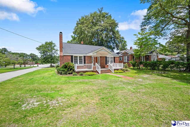 1461 King Ave, Florence, SC 29501 - view of front of house featuring brick siding, a front yard, and a chimney