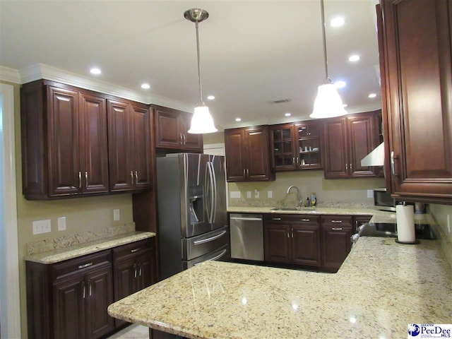 kitchen featuring a sink, decorative light fixtures, under cabinet range hood, stainless steel appliances, and a peninsula