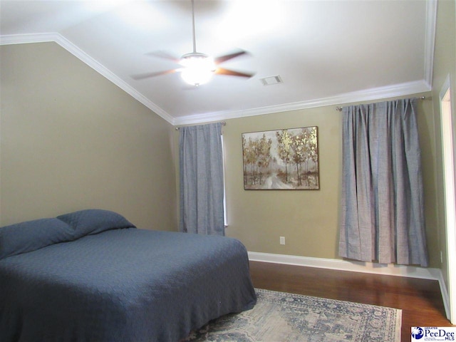 bedroom featuring visible vents, crown molding, baseboards, lofted ceiling, and wood finished floors