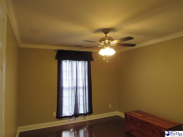 empty room with visible vents, crown molding, baseboards, dark wood-style floors, and a ceiling fan