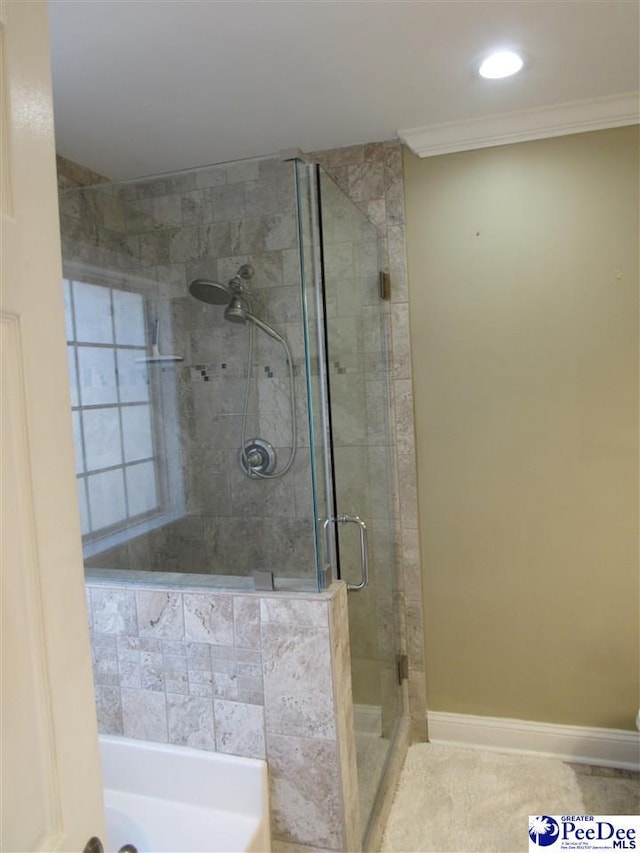 full bathroom featuring a garden tub, a stall shower, baseboards, and ornamental molding