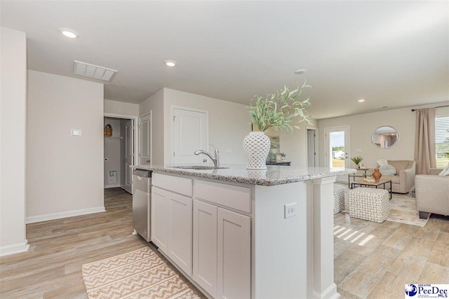 563 Strawberry Field Way, Galivants Ferry, SC 29544 - kitchen with light wood-style floors, light stone counters, white cabinets, open floor plan, and a kitchen island with sink