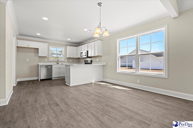 kitchen featuring light countertops, appliances with stainless steel finishes, dark wood finished floors, and baseboards